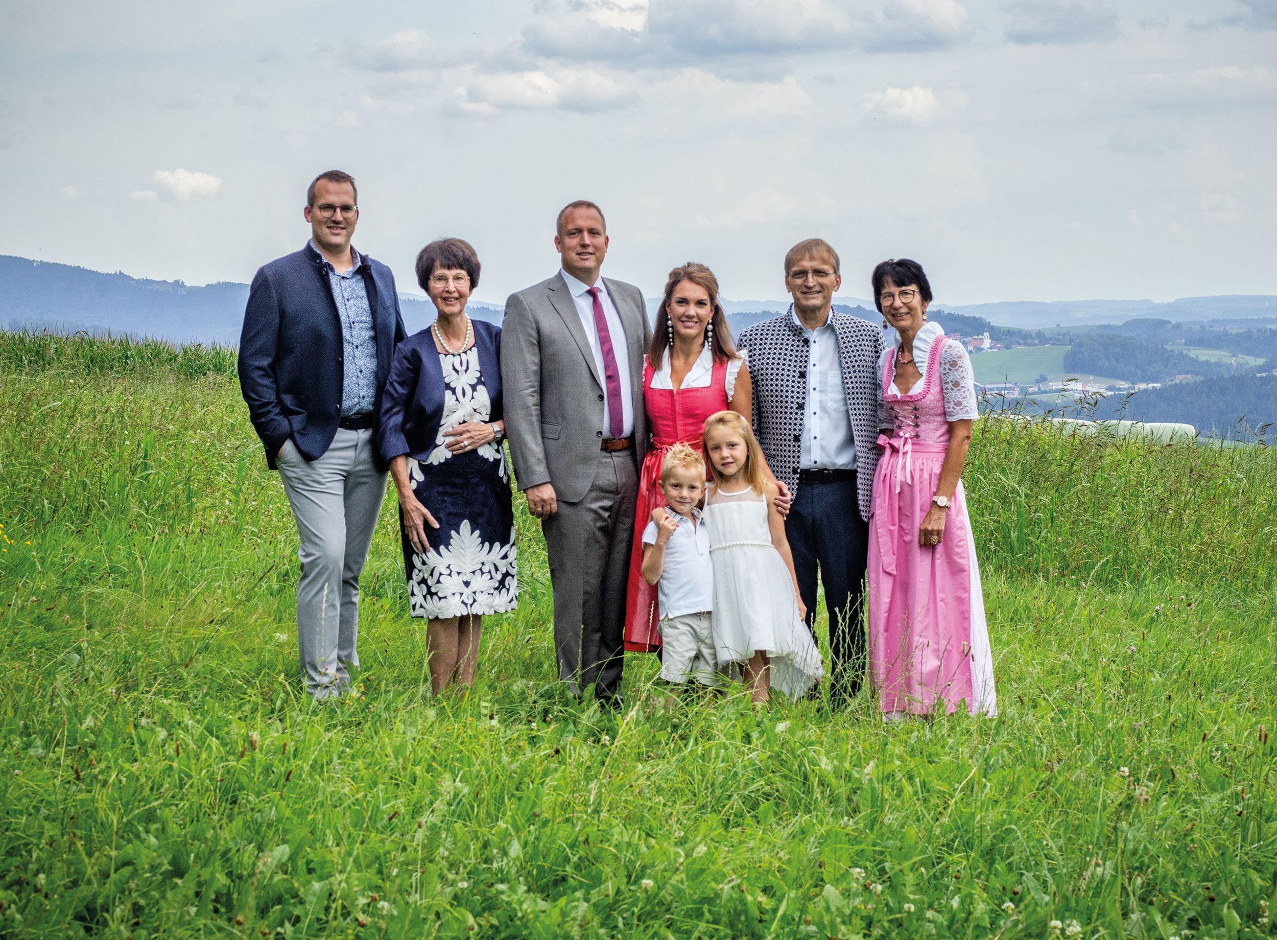 A family group outdoors with a mountainous backdrop.