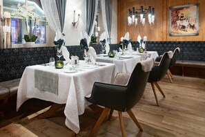 A restaurant with tables set for dining, wooden flooring, and a chandelier. - SINGLE ROOM CLASSIC - 5* Wellness & Sporthotel Jagdhof (Röhrnbach)