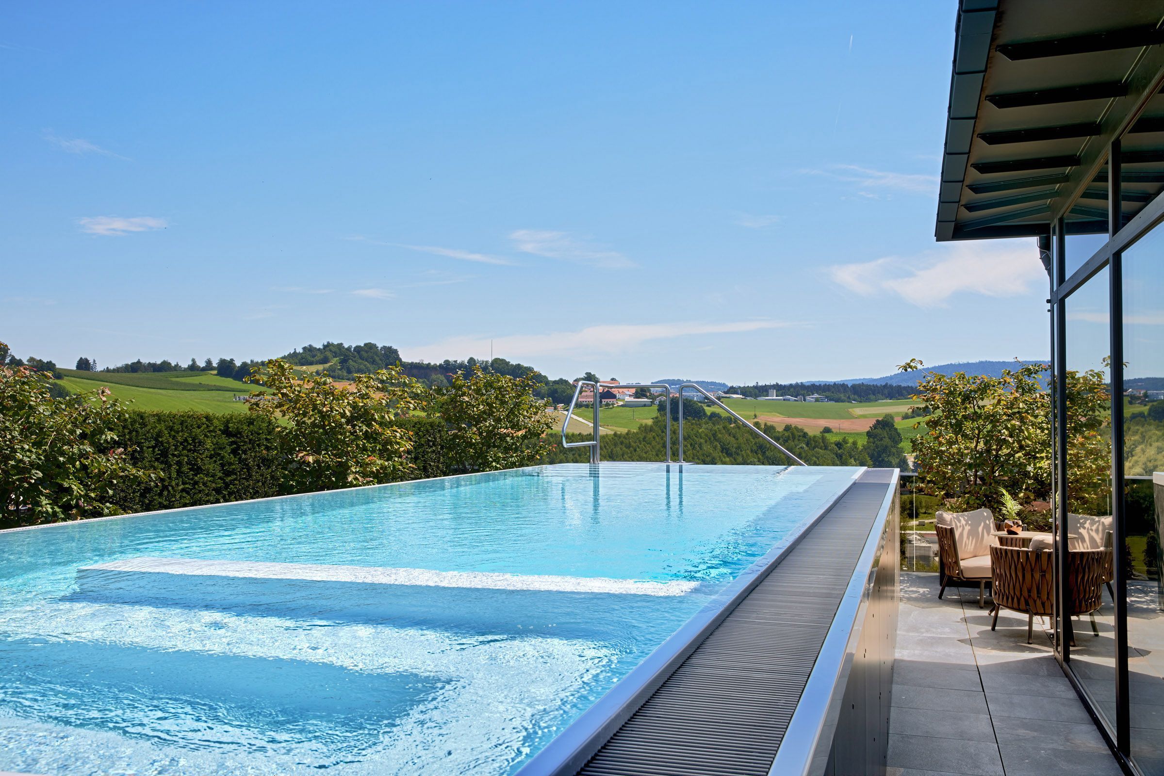 A rooftop infinity pool with a clear view of the countryside.
