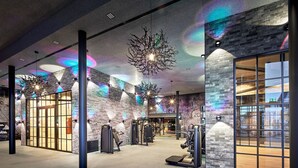 A gym with exercise equipment, a brick wall, and a large window.
