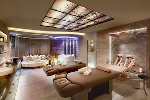 A modern spa with a massage table, seating area, and a hot tub. - HONEYMOON-SUITE - 5* Wellness & Sporthotel Jagdhof (Röhrnbach)