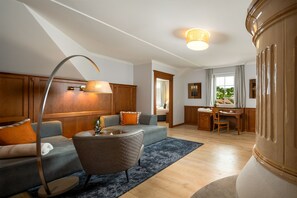Una sala de estar moderna con un sofá, un sillón, un escritorio y una lámpara.
