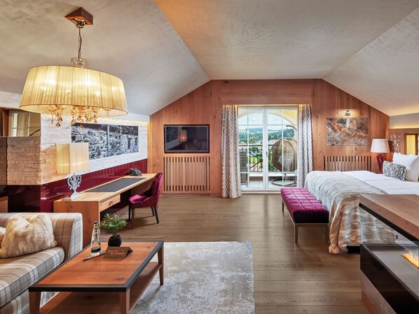 Une pièce spacieuse comprenant un grand lit, un bureau, une chaise, un canapé et un balcon avec vue.