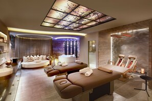 Un spa moderne doté d’une table de massage, d’un espace détente et d’un bain à remous.