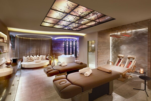 Un spa moderne doté d’une table de massage, d’un espace détente et d’un bain à remous.