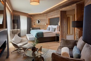 Una habitación de hotel moderna con cama, zona de estar y chimenea.