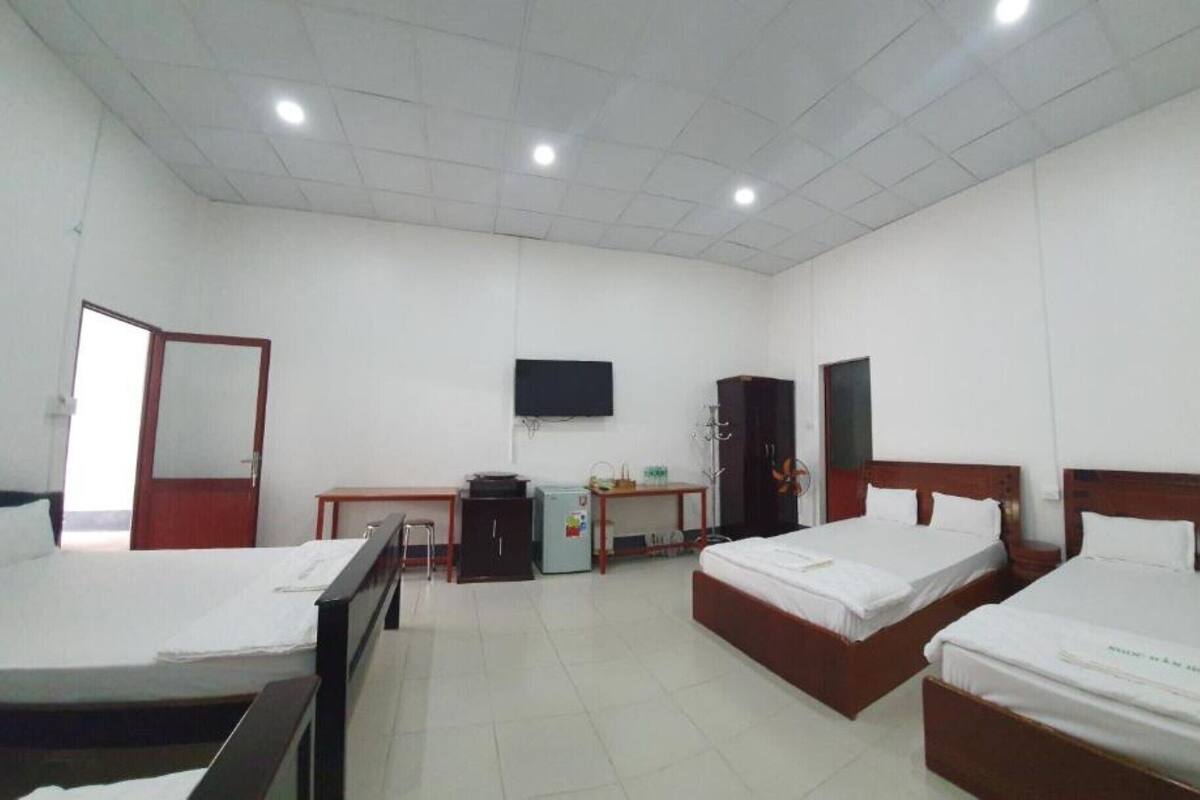 A hotel room with two beds, a desk, a television, and a wardrobe.