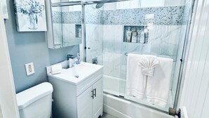 Een moderne badkamer met toilet, wastafel en douche.