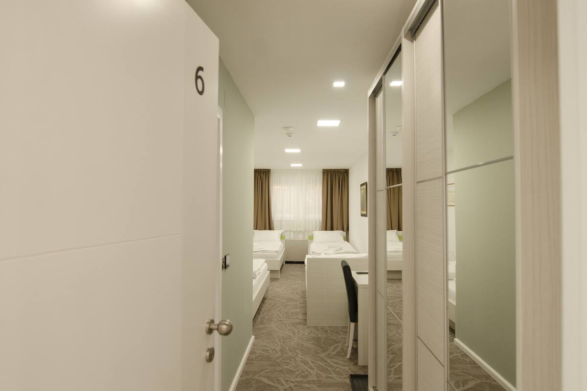 A hotel room with a double bed, a desk, and a chair.