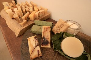 A wooden board with various cheese blocks and a candle. - Baisha 35 Homestay (Hengchun)
