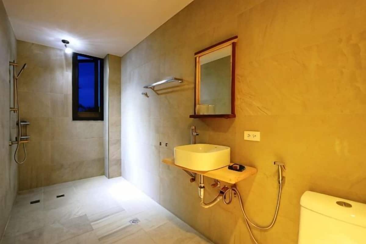 Une salle de bain avec une douche, un lavabo et des toilettes.