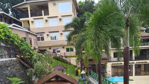 A courtyard with a wooden gazebo, outdoor seating, and potted plants. - Seascape Resort (Bauan)