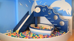 A children's play area with a slide, a boat-shaped play structure, and colorful balls. - Kid Baby Homestay (Tainan)