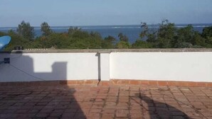 A rooftop terrace with a view of the ocean and trees. - Belle Ocean View Apartments (Mombasa)