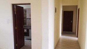 A spacious hallway with tiled flooring leading to a kitchen area. - Belle Ocean View Apartments (Mombasa)