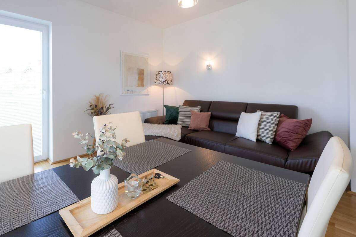 A modern living room with a sofa, coffee table, and decorative items.