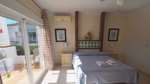 A bedroom with a bed, a nightstand, a lamp, and a window with curtains. - Nerja Paradise Rentals - Villa Kaisaras (Nerja)