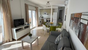 Un apartamento moderno con sala de estar, comedor, kitchenette y un balcón.