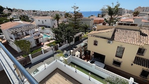 A residential area with a pool, terraced houses, and a view of the sea. - Nerja Paradise Rentals - Villa Las Palmeras (Nerja)