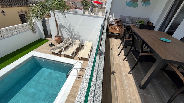 A rooftop pool area with lounge chairs, a dining table, and a view of the neighborhood. - Nerja Paradise Rentals - Villa Las Palmeras (Nerja)