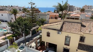 A residential area with a pool, a car, and a view of the sea. - Nerja Paradise Rentals - Villa Las Palmeras (Nerja)