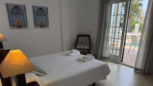 Une chambre d’hôtel avec un lit, une lampe, une chaise et une vue sur l’extérieur.