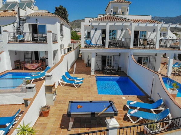 Relax by the two pools, surrounded by lounge chairs and a pool table.