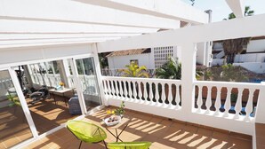 A sunlit patio with a white railing, a table with chairs, and exercise equipment. - Nerja Paradise Rentals - Villa Almassora (Nerja)