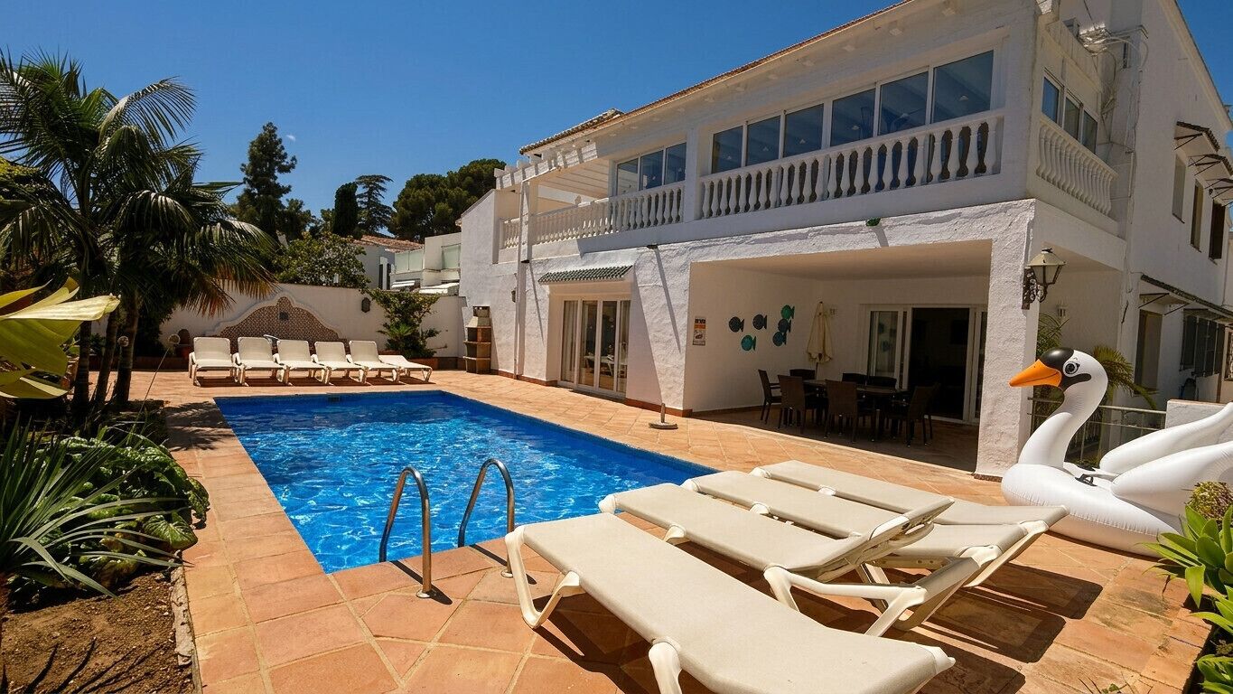A poolside area with lounge chairs, a swimming pool, and a swan decoration.