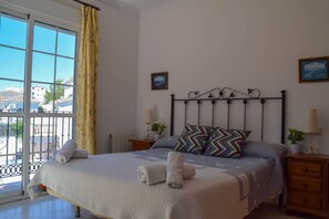 Cozy retreat with a large bed, bedside table, and framed picture.