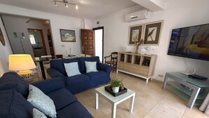 A living room with a sofa set, a coffee table, a TV, and a cabinet.