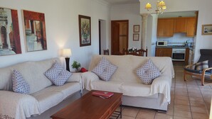 A living room with a sofa set, a coffee table, and a dining area with chairs. - Nerja Paradise Rentals - Villa Los Girasoles (Nerja)