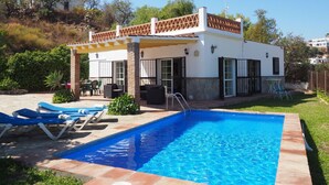A modern house with a swimming pool, patio furniture, and a covered outdoor area. - Nerja Paradise Rentals - Villa Los Girasoles (Nerja)