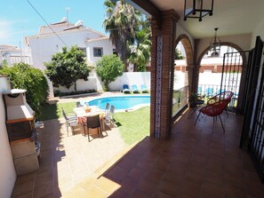 Un patio con piscina, mobili da esterno e vista sul quartiere.