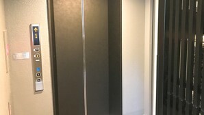 An elevator with a control panel featuring directional arrows and a wheelchair accessibility symbol. - Hotel Livemax Asakusa Ekimae (Tokyo)