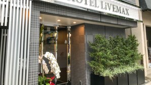 The exterior of Hotel Livemax with a tiled facade, a glass entrance, and a potted plant to the right. - Hotel Livemax Asakusa Ekimae (Tokyo)