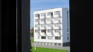 Un bâtiment moderne de couleur blanche, doté de nombreux balcons et fenêtres.