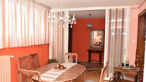 A dining area with a wooden table, chairs, and a chandelier. - Apartments Oldtimer (Zagreb)
