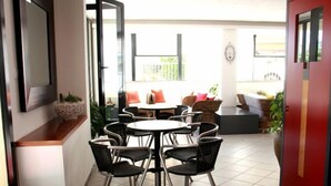 Een moderne eethoek met een ronde tafel en zwarte stoelen.