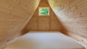 A wooden interior with a sloped ceiling and a small window at the top. - Kamp Slapic Glamping (Duga Resa)