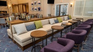Un hall d’hôtel avec un canapé, des fauteuils et des tables.