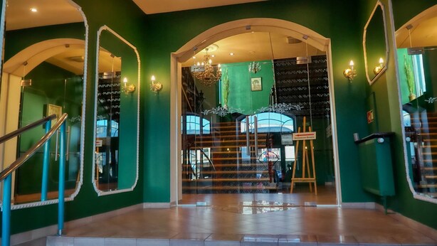 A grand staircase with a glass railing, leading to a lower level. - Hotel Polonia Racibórz (Raciborz)