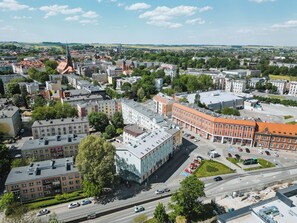 An aerial view of a cityscape with a mix of modern and historic buildings, a prominent church, and a clear sky. - Hotel Polonia Racibórz (Raciborz)