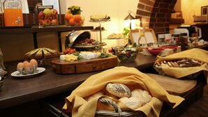 A buffet with various food items and a brick wall in the background. - Hotel Polonia Racibórz (Raciborz)
