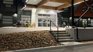 A modern building with a stone facade, a wooden ceiling, and a staircase leading to the entrance. - Quality Hotel & Conference Centre (Edmundston)