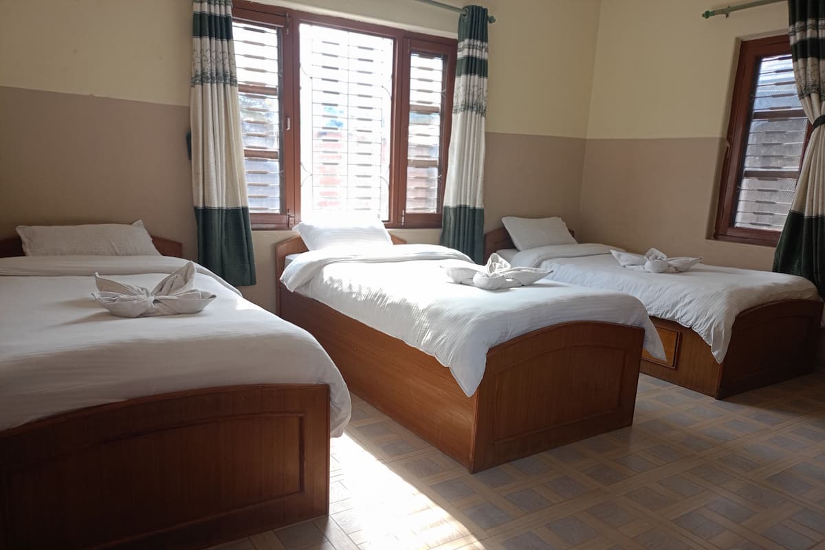 A hotel room with two wooden beds, white bedding, and a tiled floor.