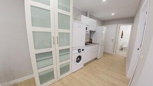 Une cuisine moderne équipée d’un lave-linge, d’un four à micro-ondes et d’un four encastré.