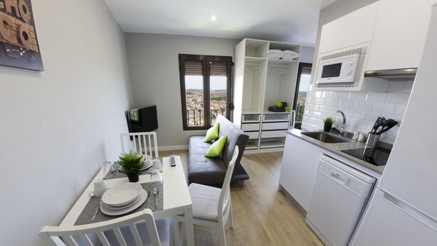 A compact kitchen with white cabinets, a built-in microwave, and a dishwasher.