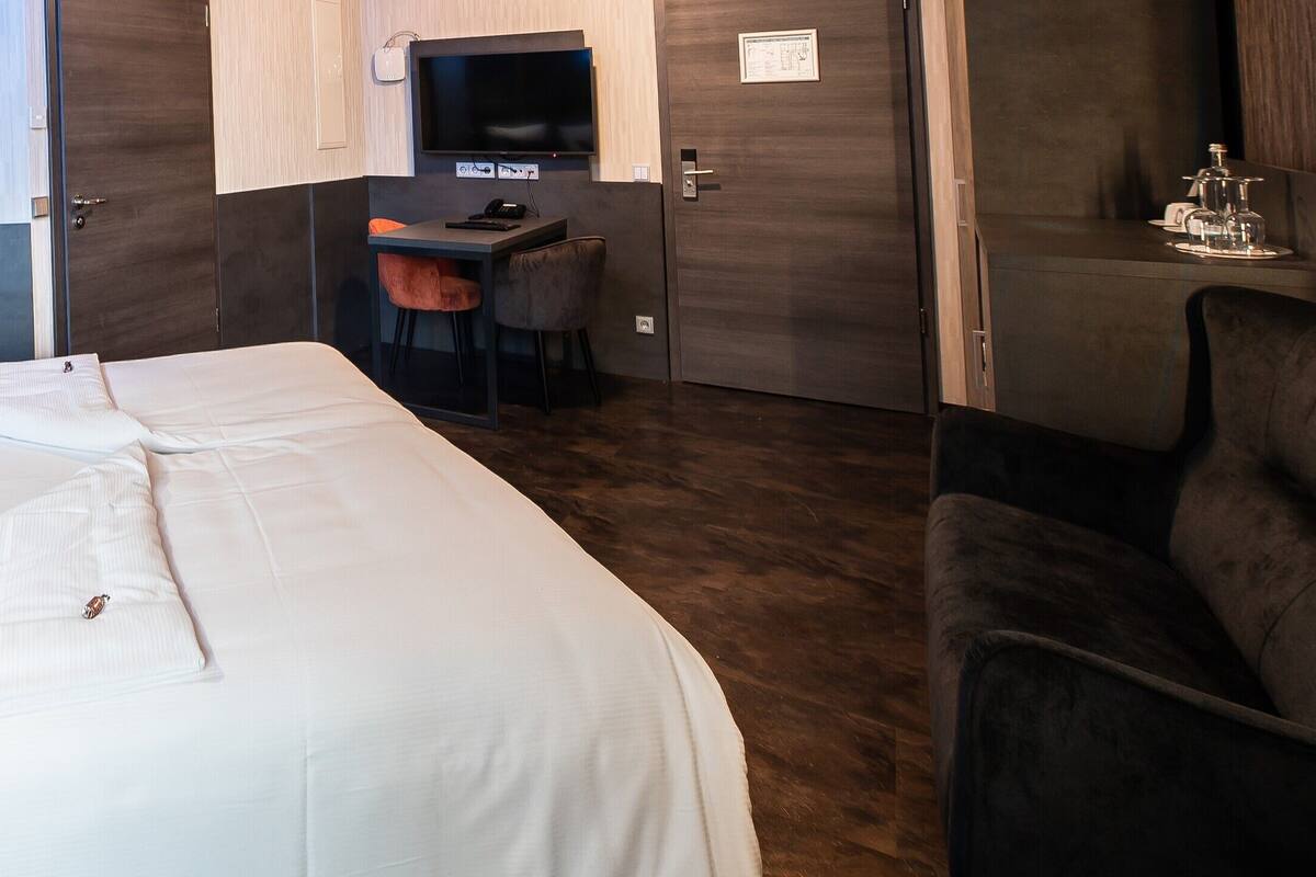 Ein Hotelzimmer mit einem großen Bett, einem Schreibtisch und einem Stuhl.