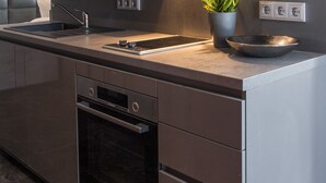 Una cocina moderna con horno integrado, un lavabo y una estufa.